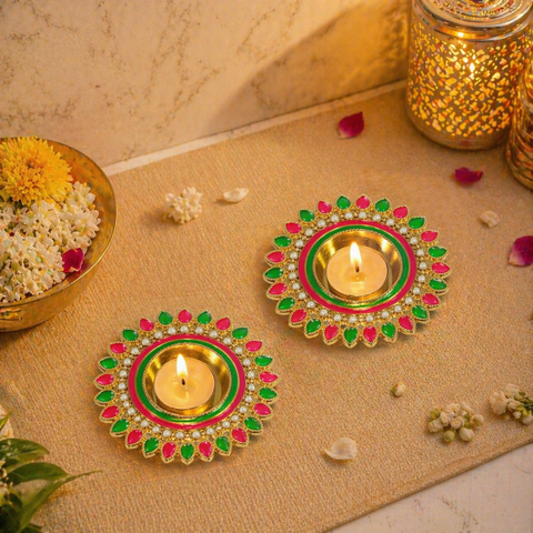 Decorative Diwali lamps with candles on a textured surface with flowers and jars.