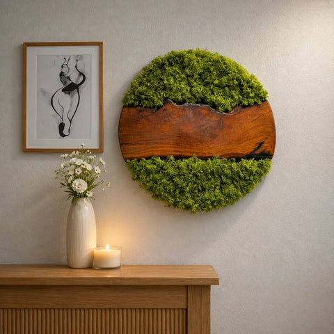 Moss wall art on a wall with a vase and candle on a wooden surface.