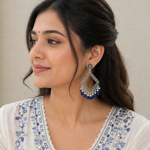 woman wearing oxidised silver diamond shape drop earrings with blue beads ethnic jewellery lifestyle image