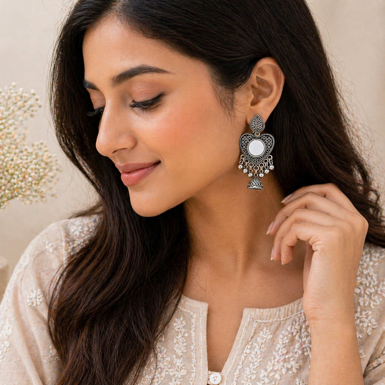 Woman wearing ornate earrings with a neutral background