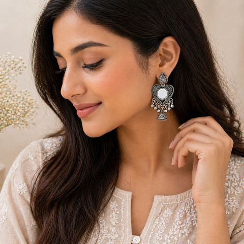 Woman wearing ornate earrings with a neutral background