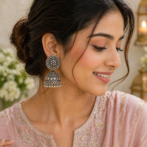 Woman wearing silver earrings with a blurred background