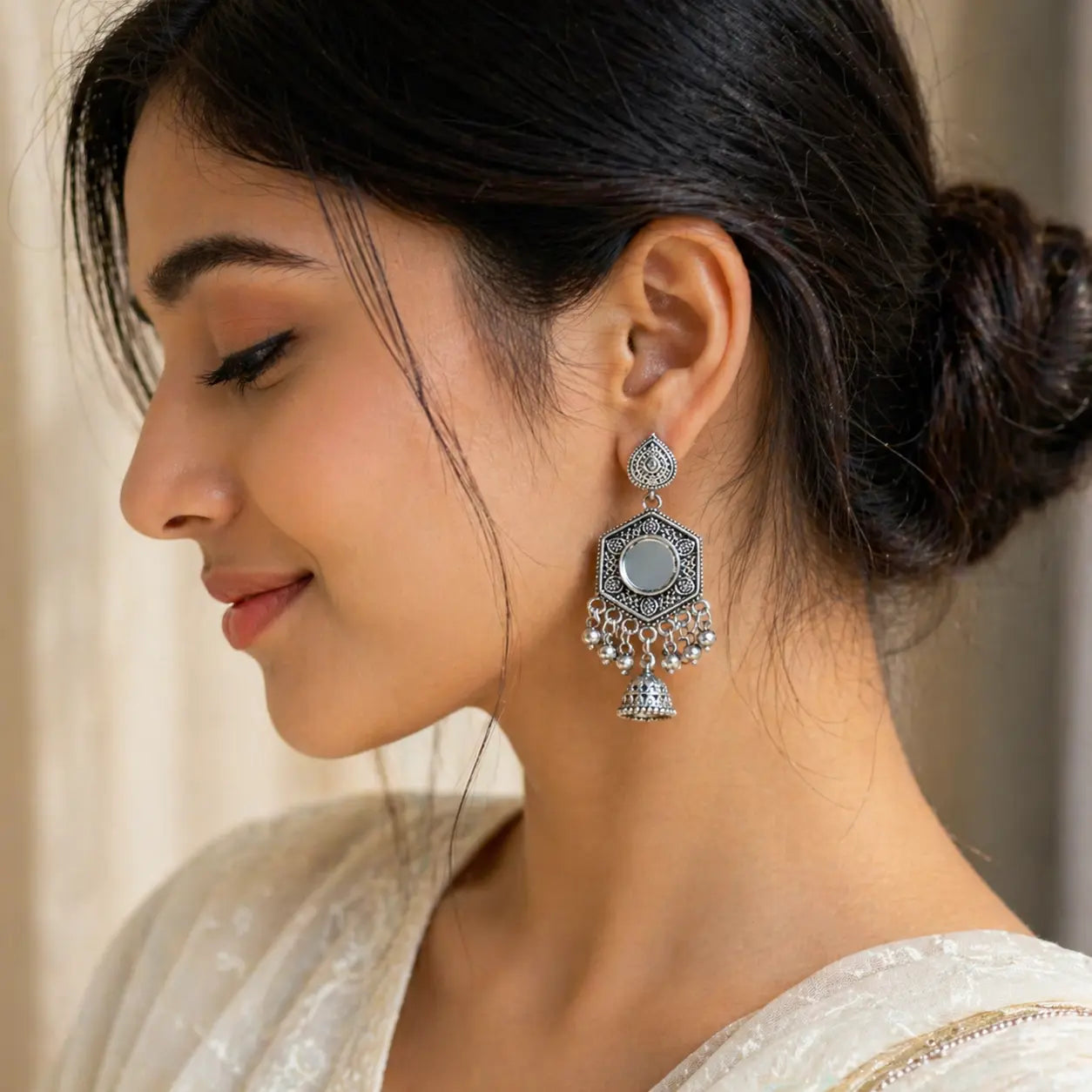 Woman wearing a decorative earring with a neutral background