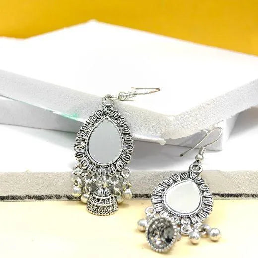 Oxidised silver mirror drop jhumka earrings with teardrop design and bead detailing placed on minimal background