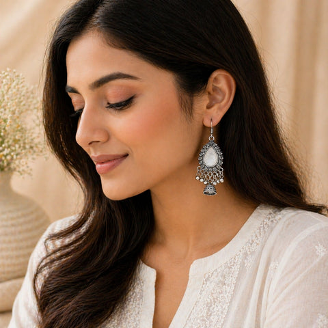 Woman wearing oxidised silver mirror jhumka earrings with teardrop design and bead drops ethnic jewellery look
