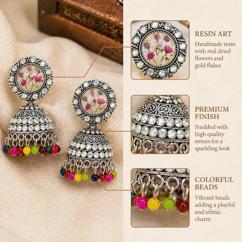 Decorative earrings with colorful beads and detailed design on a beige background