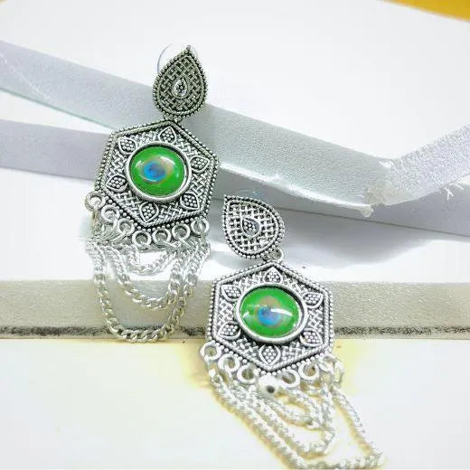 Silver earrings with green gemstones on a white background