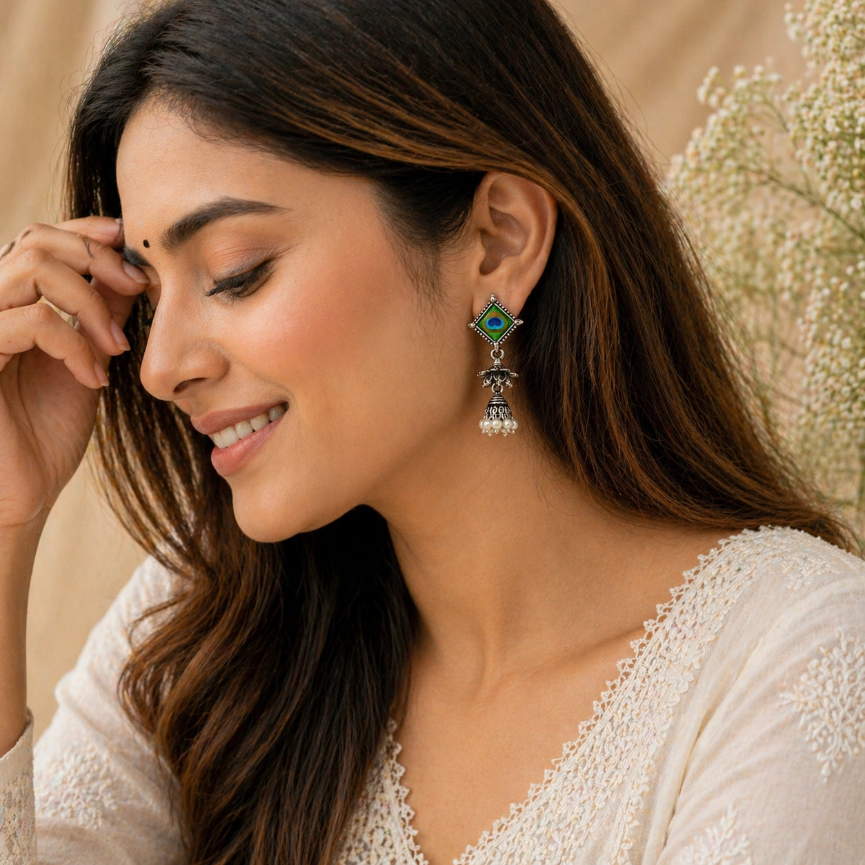 Woman wearing a decorative earring with a neutral background
