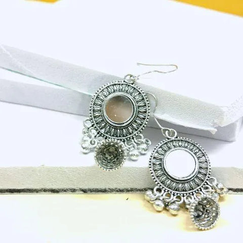 Pair of silver earrings with circular designs and dangling elements on a white background.