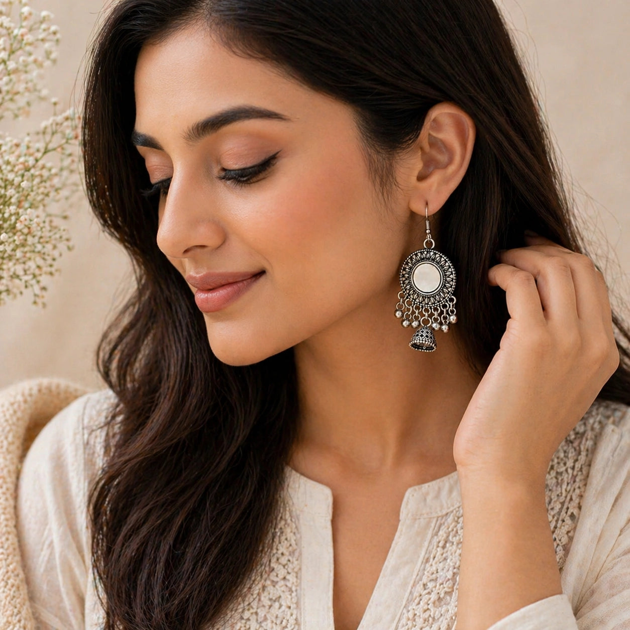 Woman wearing a silver earring with a floral background