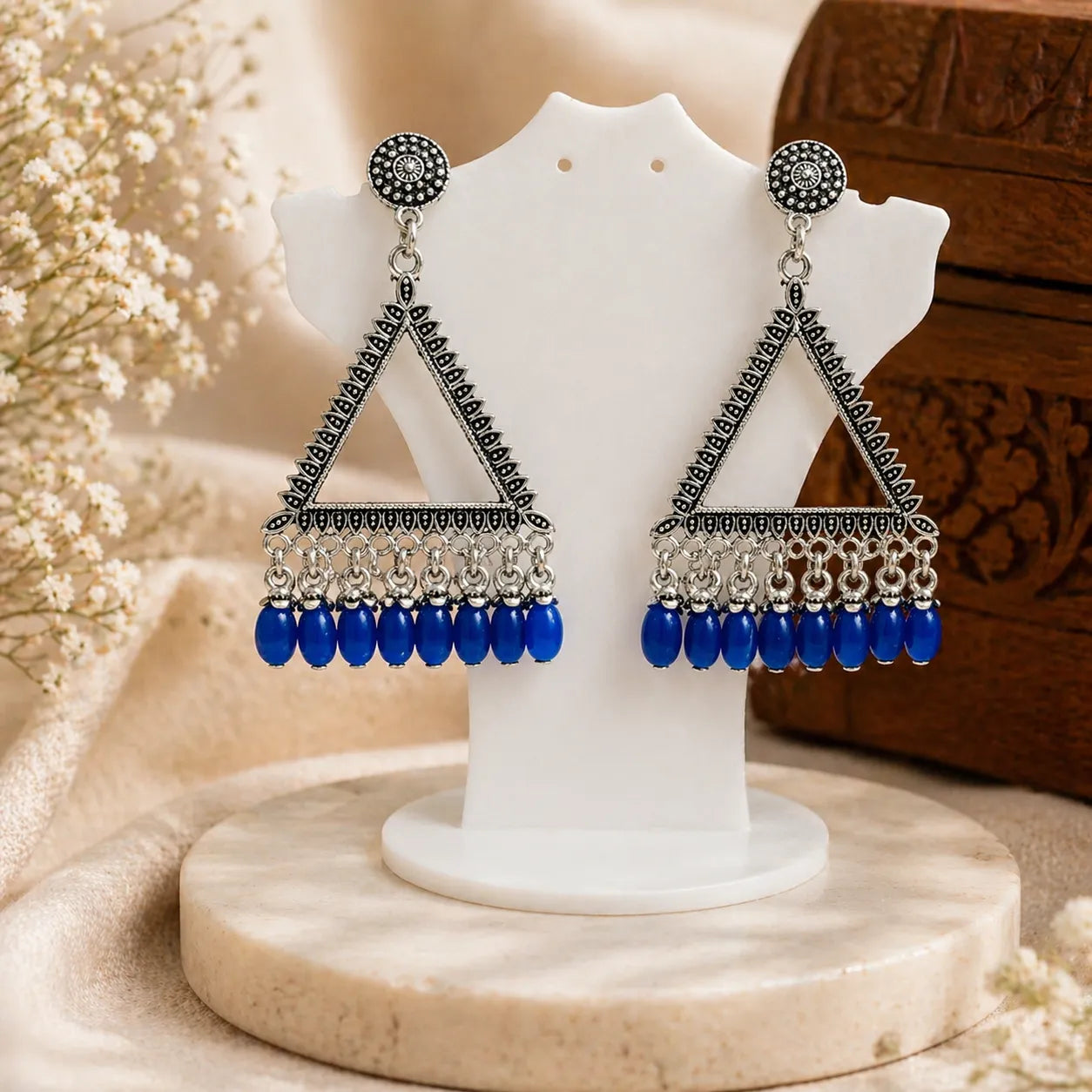 oxidised silver triangle drop earrings with blue beads displayed on stand ethnic jewellery product image