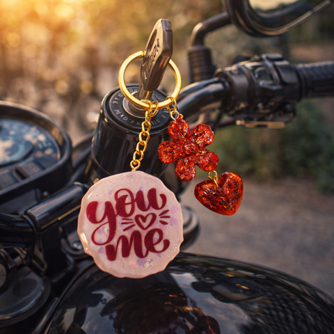 Keychain with 'You Me' text on a motorcycle handlebar