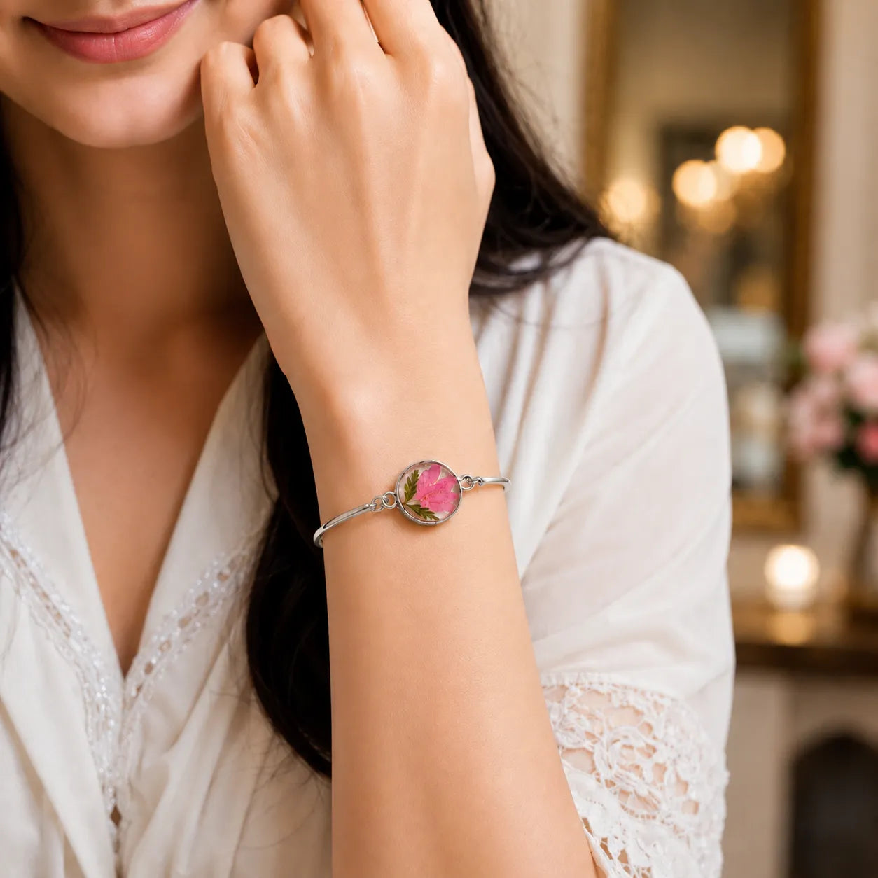 Woman wearing a bracelet with a pink gemstone in a softly blurred indoor setting