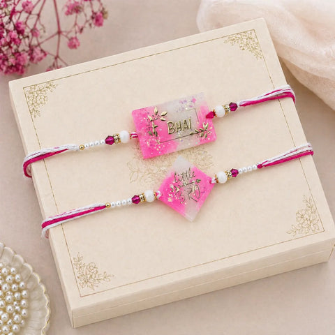 Two pink beaded Rakhi on a decorative box with floral background