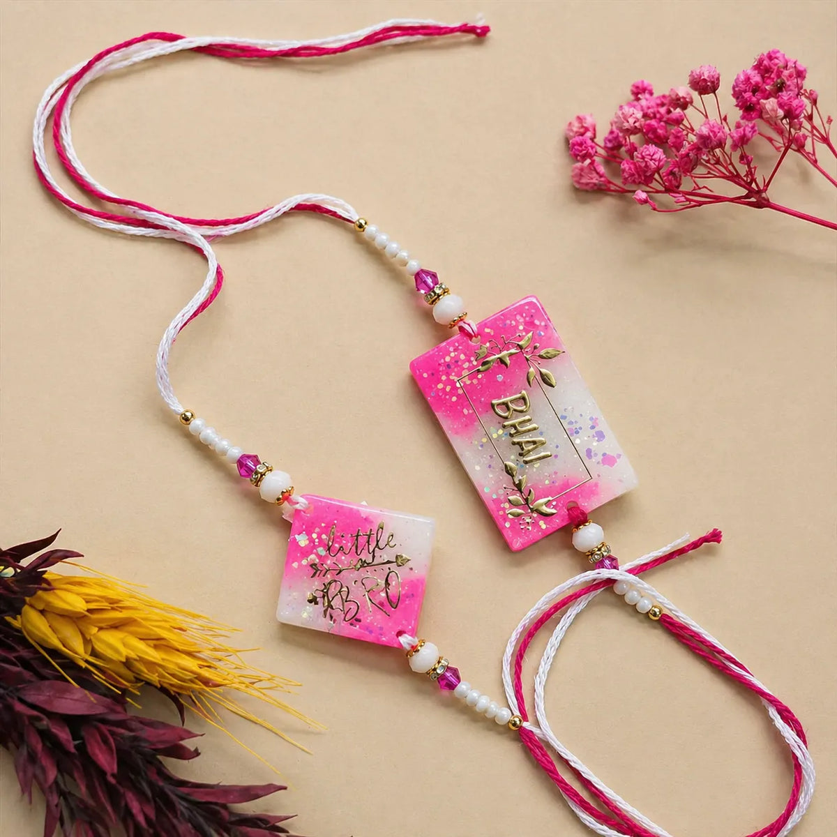 Decorative necklace with pink and white ribbons and floral elements on a beige background