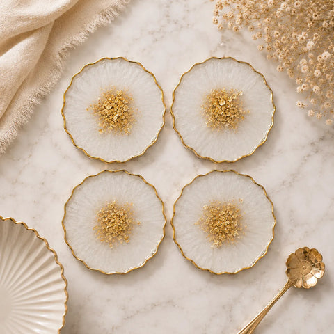 Decorative plates with gold accents on a marble surface with a gold spoon.