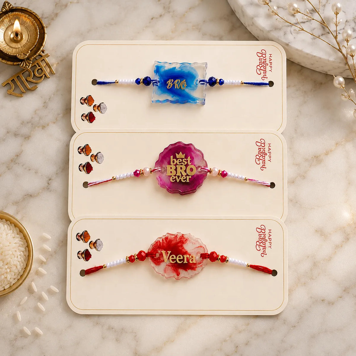 Three decorative bracelets with names on a marble surface