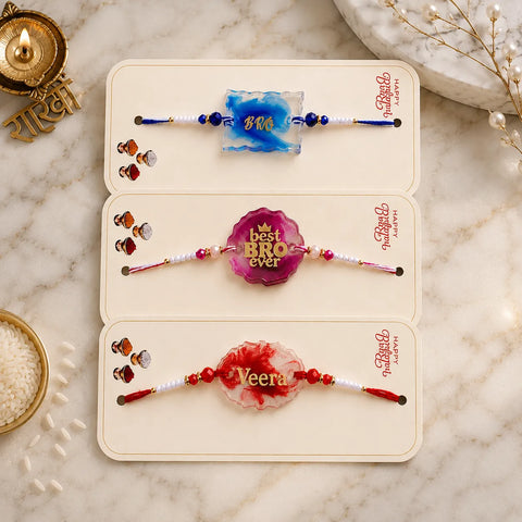 Three decorative bracelets with names on a marble surface