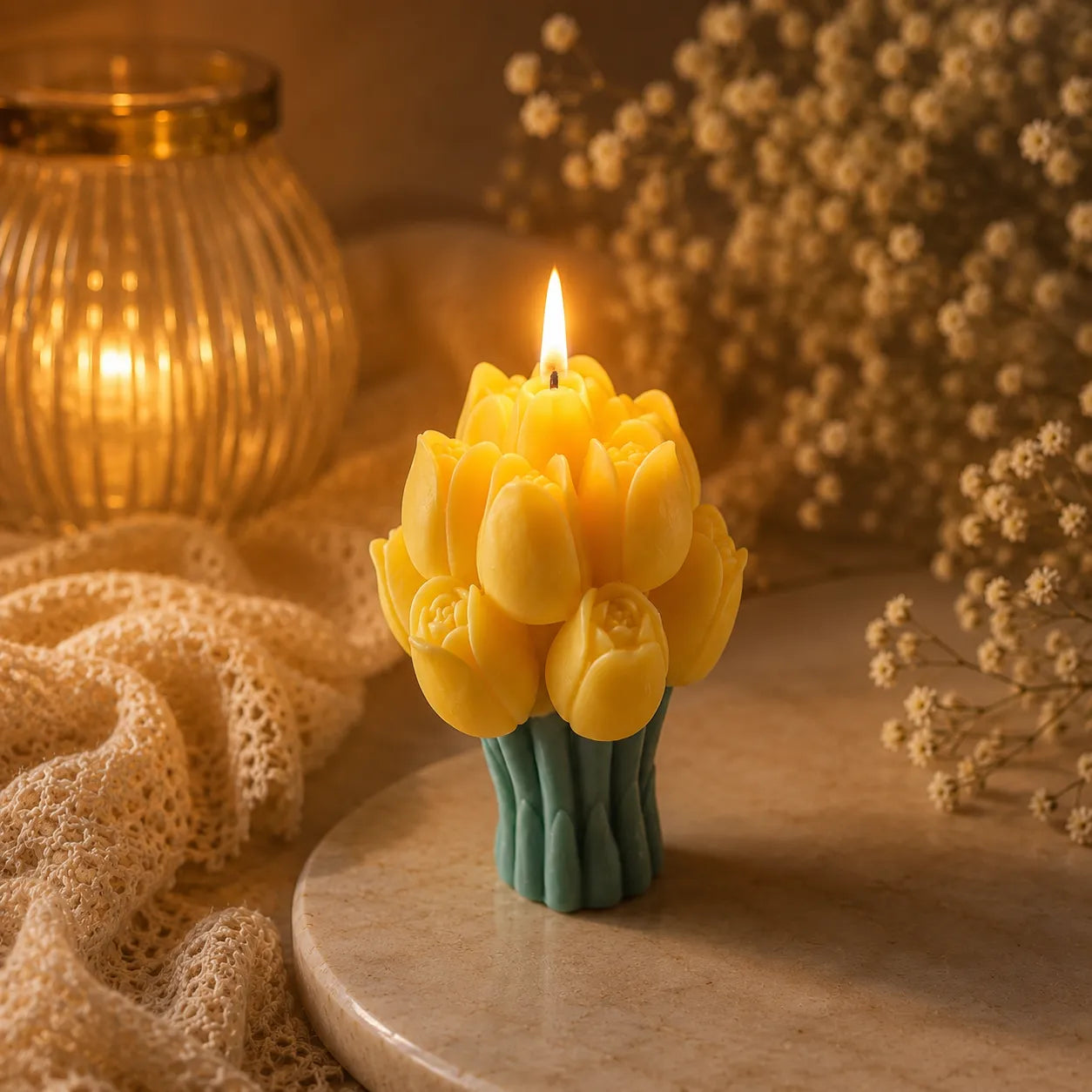 Yellow tulip-shaped candle on a wooden surface with a warm glow and decorative elements.