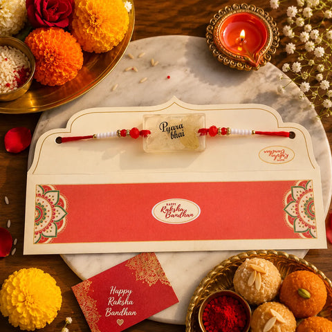 Raksha Bandhan card with rakhi, ladoos, and decorative items on a marble tray.