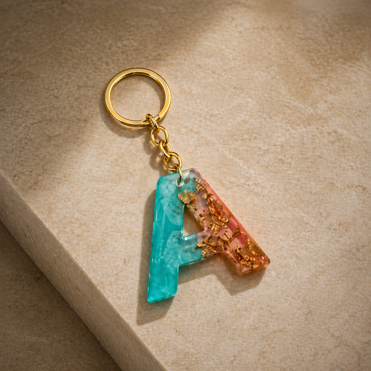 Keychain with a letter 'A' in blue and orange on a beige surface
