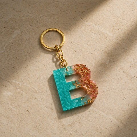 Keychain with a letter 'B' in blue and gold on a beige surface