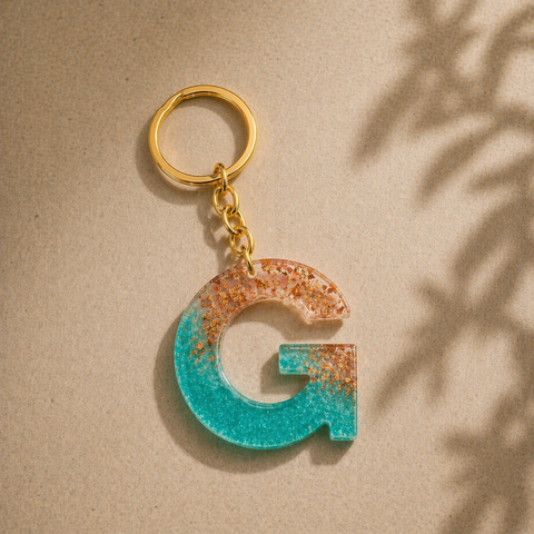 Keychain with letter 'G' design on a beige background