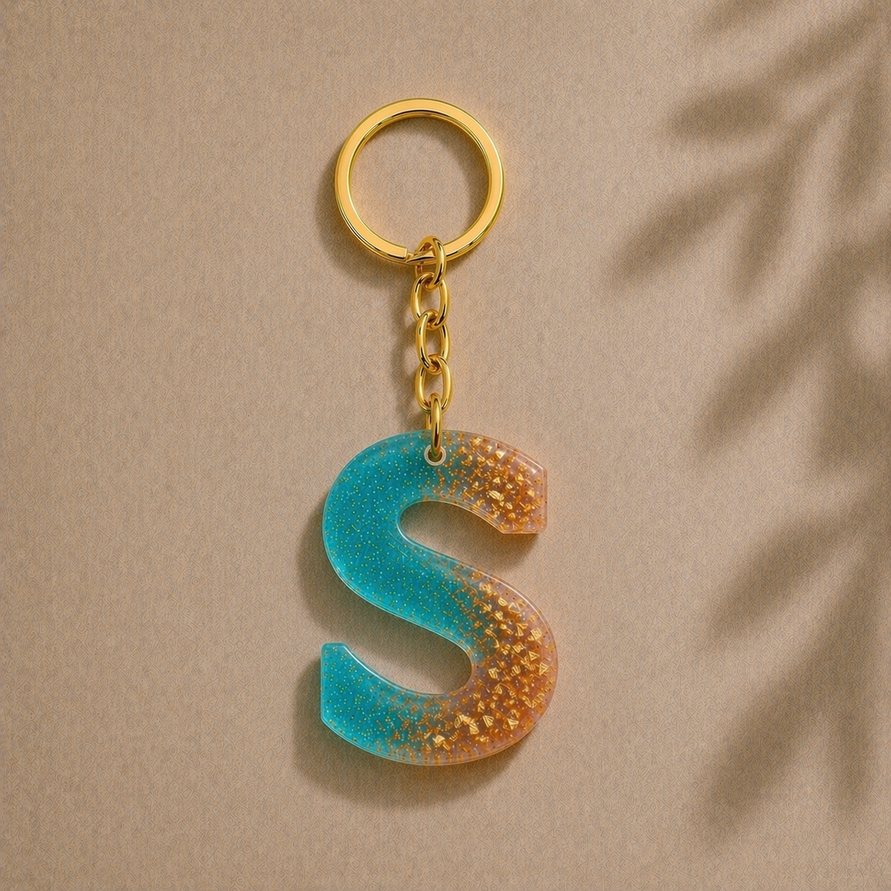 Keychain with a blue and gold letter 'S' on a beige background