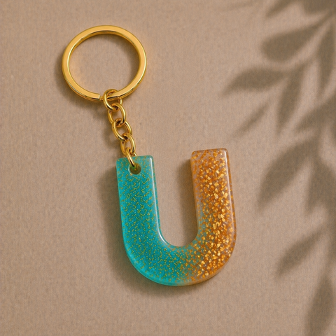 Keychain with a blue and gold letter 'U' on a beige background
