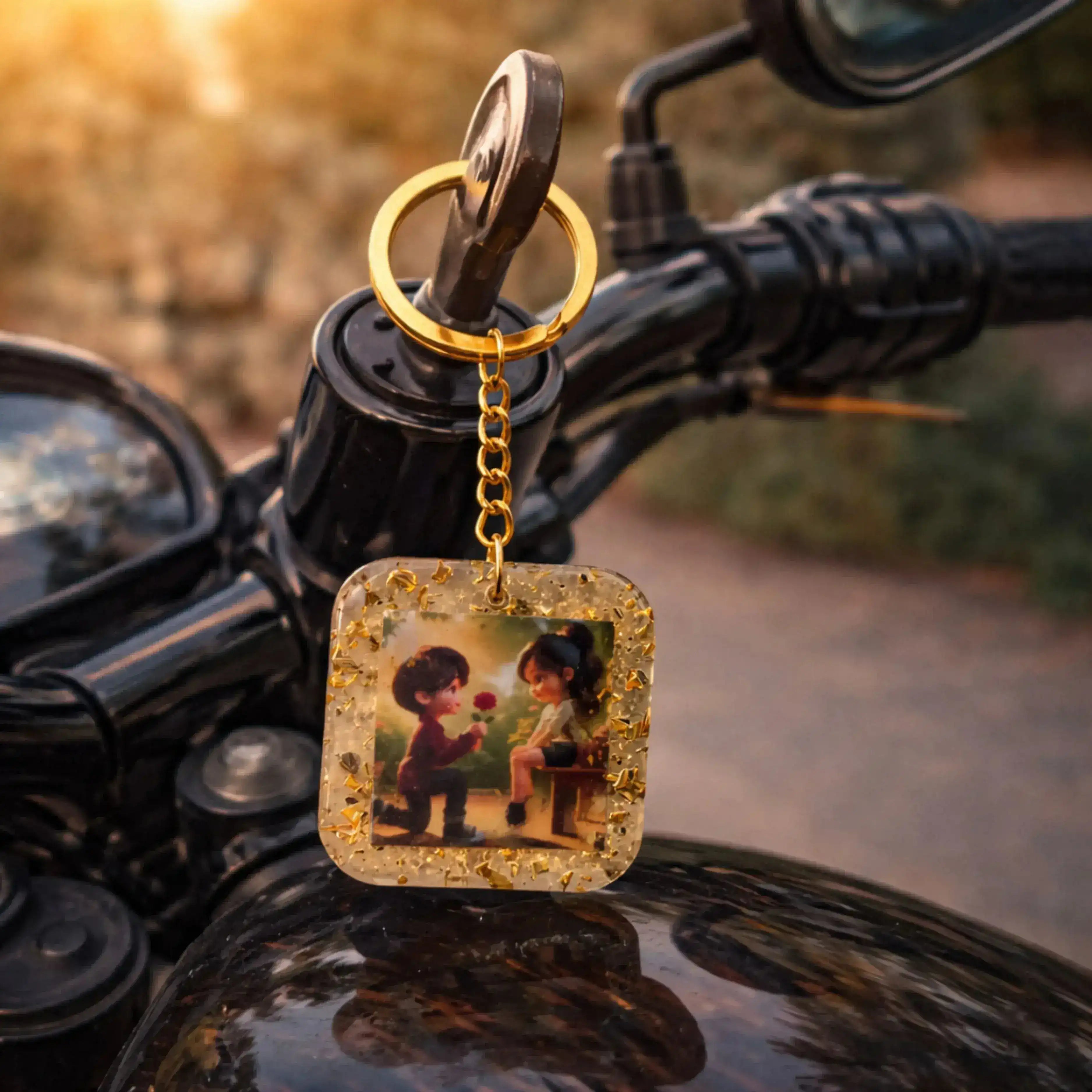 Keychain with a square pendant featuring two people on a motorcycle handlebar.