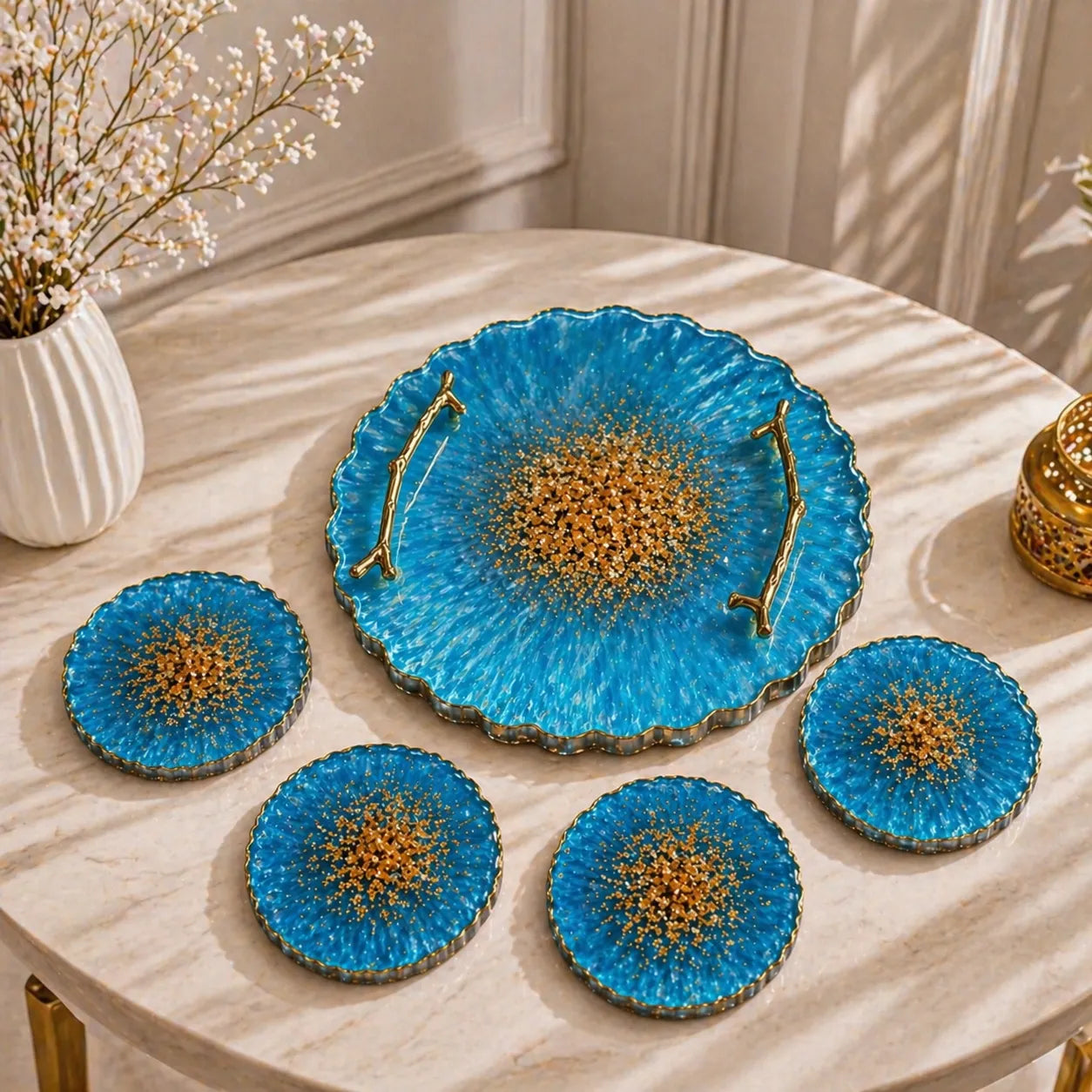Sky blue resin tray with gold handles and 4 matching geode coasters set with gold flakes placed on a marble table in home décor setup