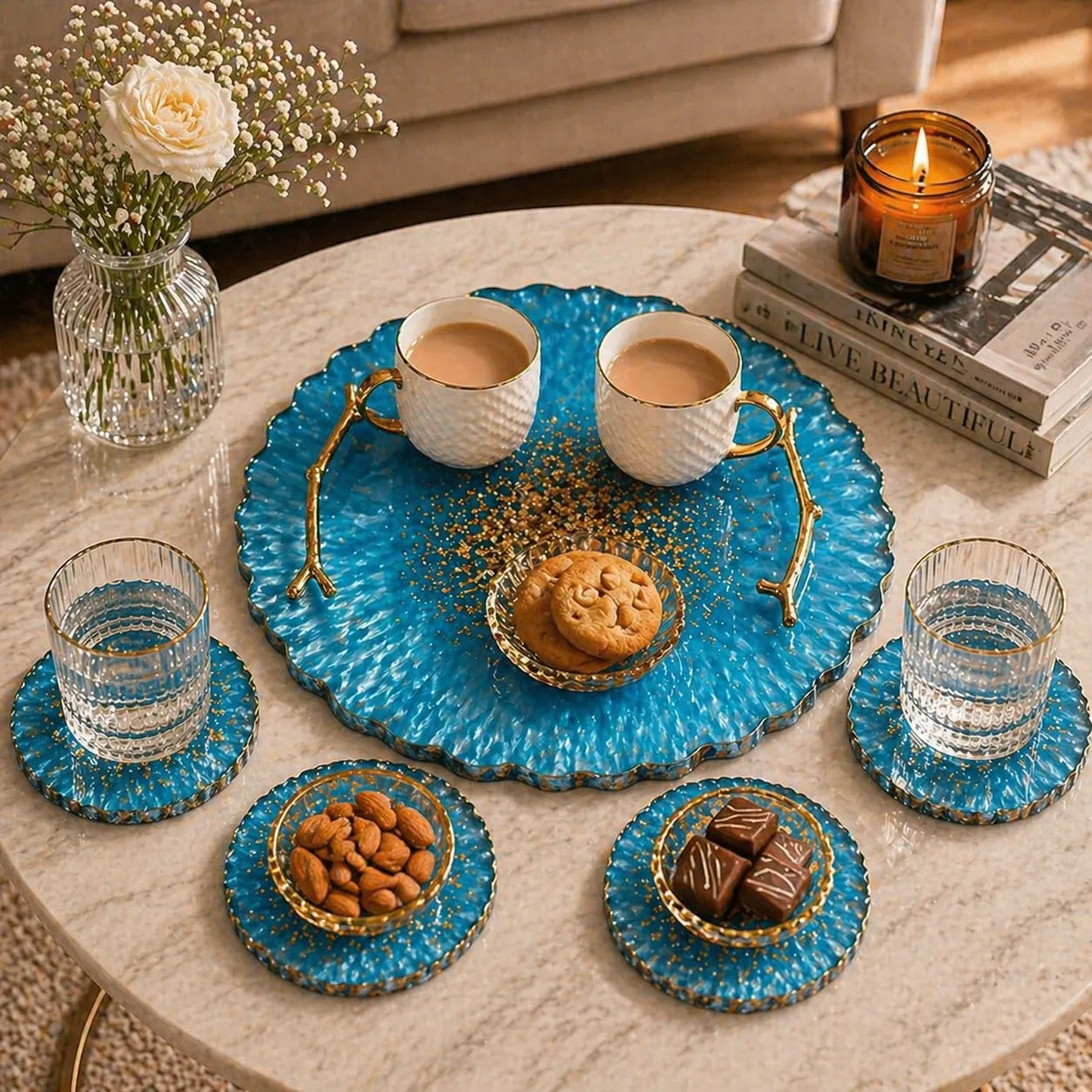 Tea set with blue ceramic tray, cups, cookies, and snacks on a marble table.