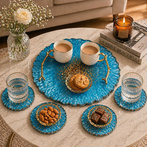 Tea set with blue ceramic tray, cups, cookies, and snacks on a marble table.