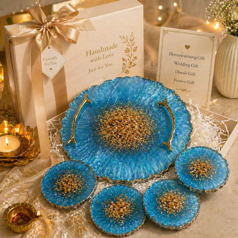 Decorative blue plates with gold accents on a table with a gift box and candles.