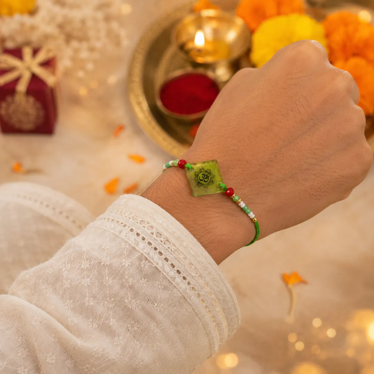 Hand wearing a green bracelet with decorative background