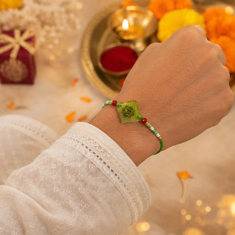 Hand wearing a green bracelet with decorative background