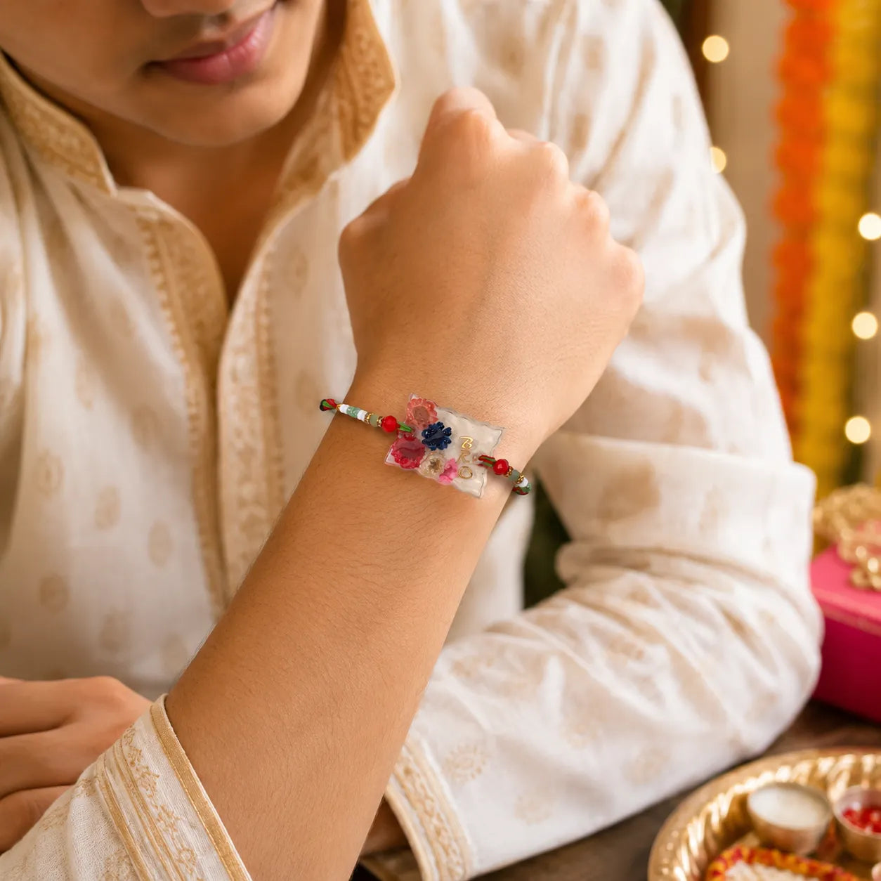 Person wearing a colorful bracelet with a blurred festive background