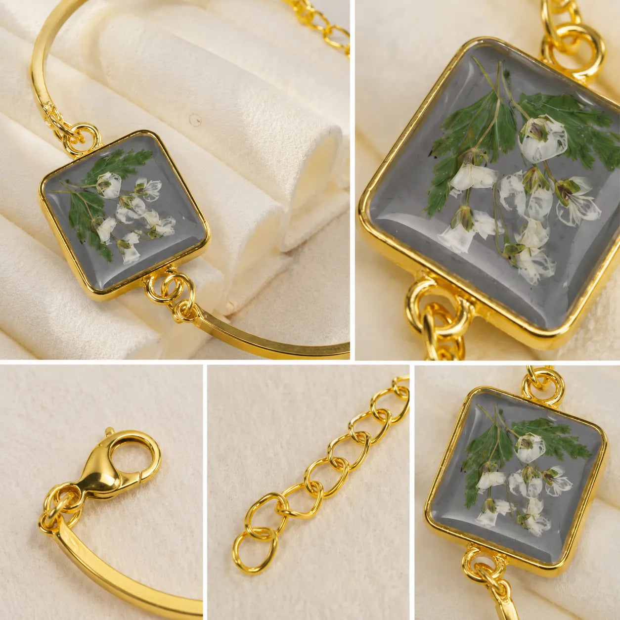 Gold bracelet with a square charm featuring pressed flowers and greenery on a beige fabric background.